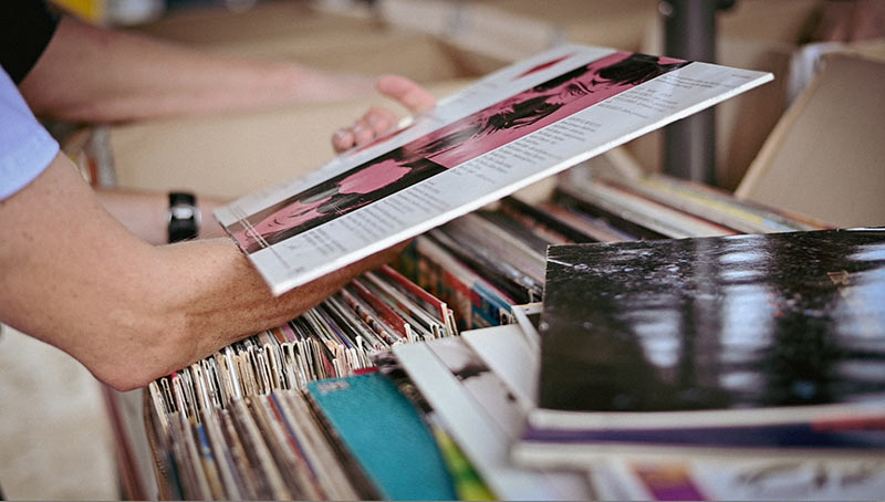 Foto: Ein Mensch sieht sich Schallplatten an (Arm, Ausschnitt)